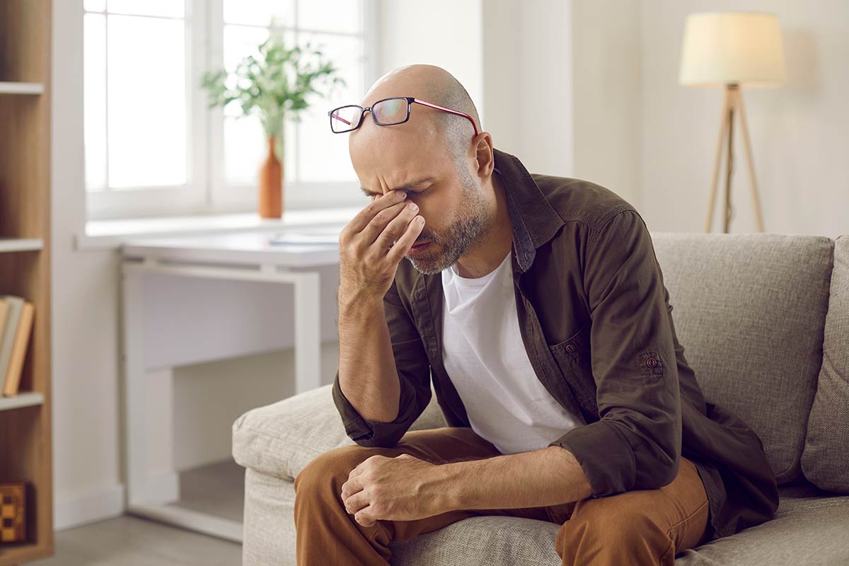 A middle aged man suffering from a migraine